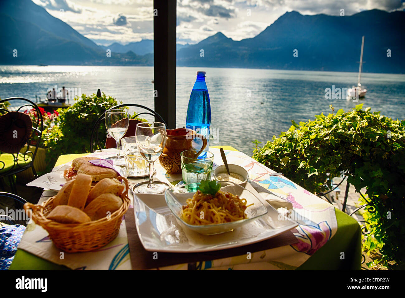 Essen auf einem Tisch im Restaurant mit Blick auf den See, Varenna, Comer See, Lombardei, Italien Stockfoto