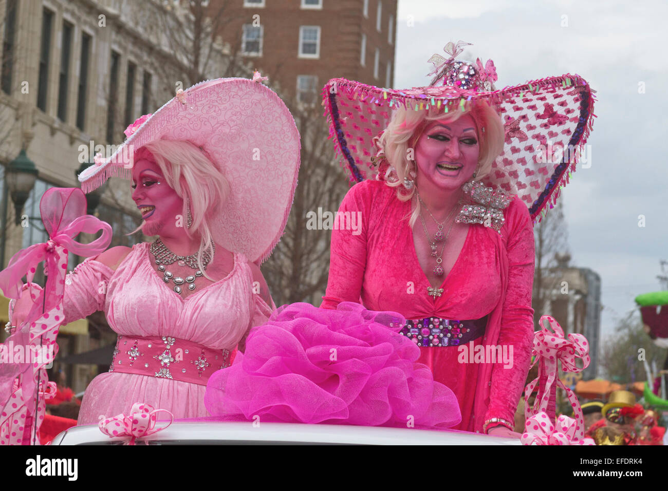 Zwei Rüschen kostümierte Damen alles in Rosa mit rosa Haut, mit einem Bart, Reiten und wave, um Menschen während der Karneval-parade Stockfoto