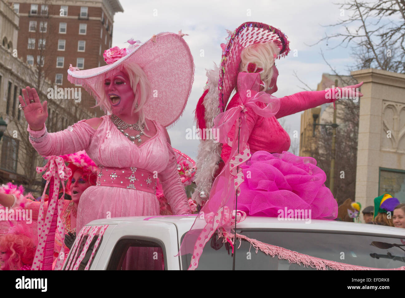 Zwei Rüschen kostümierte Damen alles in Rosa mit rosa Haut, mit einem Bart, Reiten und wave, um Menschen während der Karneval-parade Stockfoto