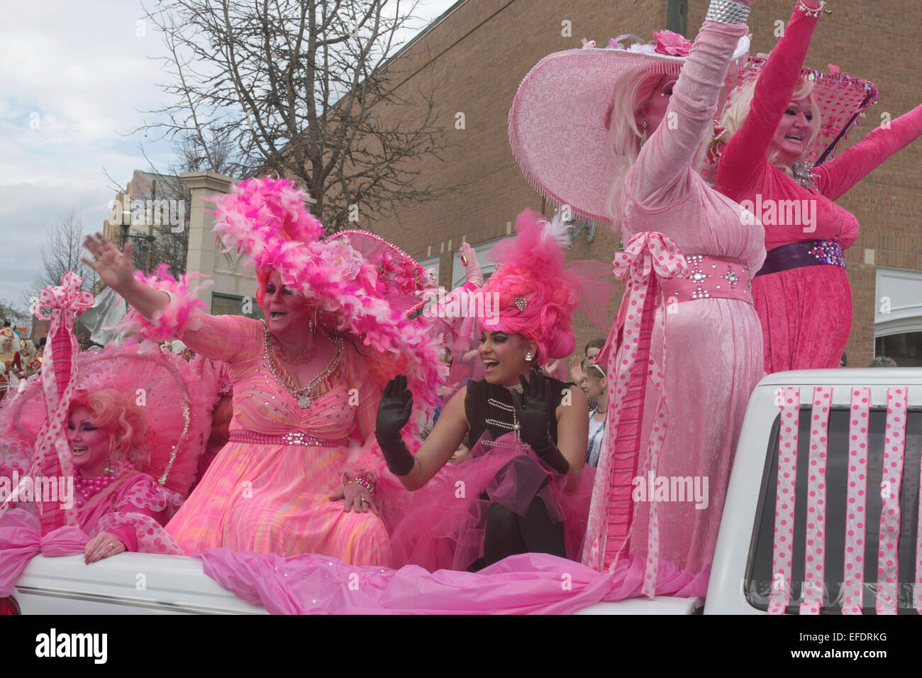 Rüschen kostümierte Damen alles in Rosa mit rosa Haut fahren und winken den Zuschauern während der Asheville, NC-Karneval parade Stockfoto
