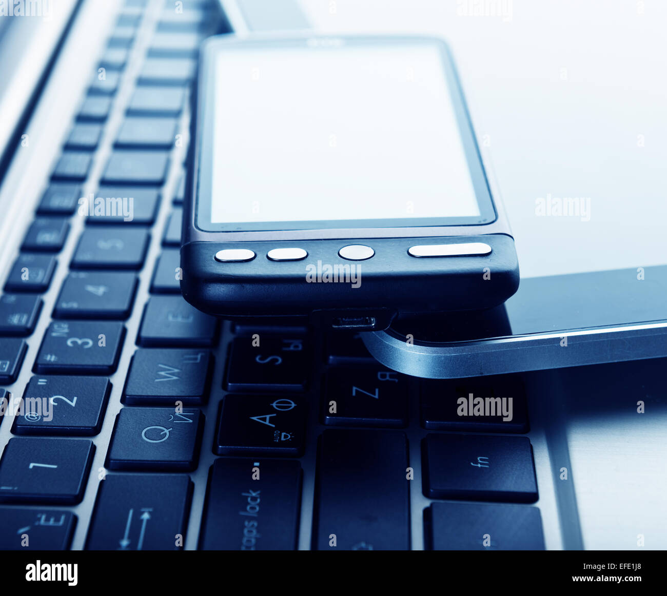 zwei Handys und Tablet-pc auf laptop Stockfoto
