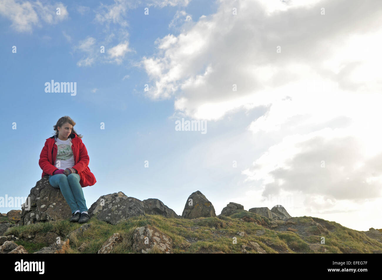 Ein 12 Jahres altes Mädchen blickt auf das Meer bei Kynance Cove, Cornwall Stockfoto