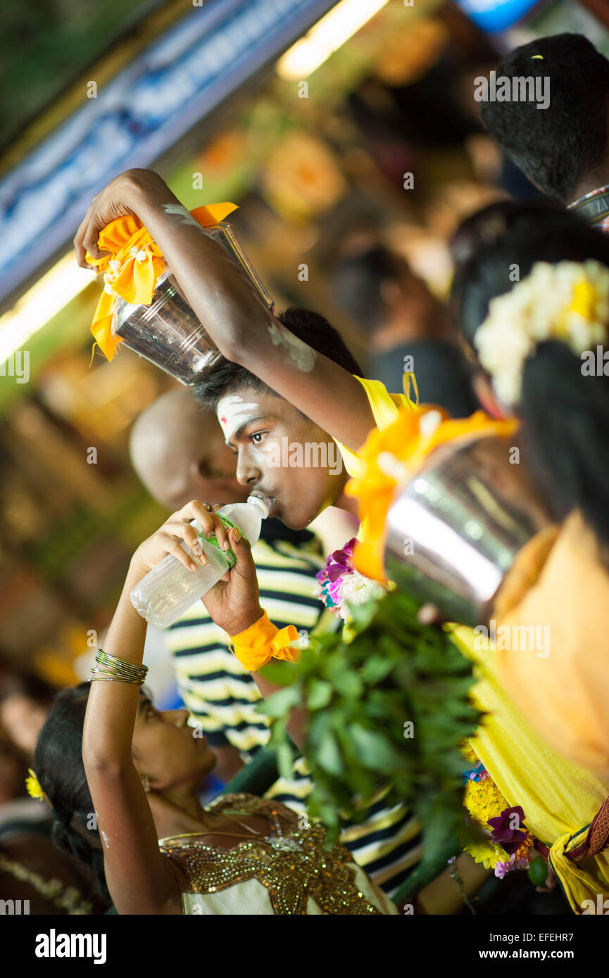 Hindu Mann Trinkwasser zwar eine Kavadi auf seinem Kopf am Thaipusam 2015 um Batu Caves Stockfoto