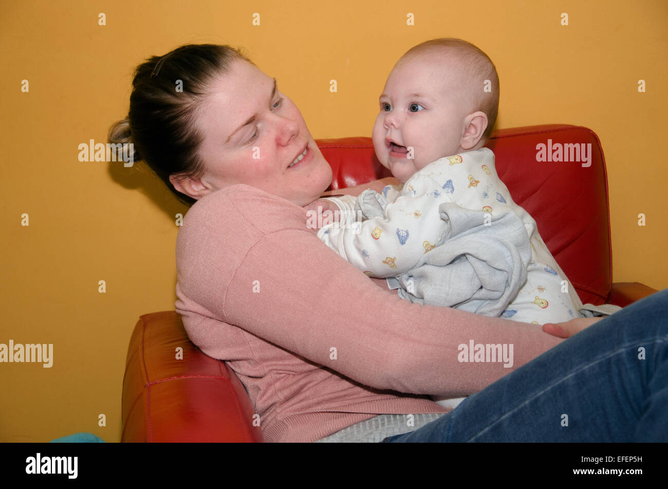 Eine Mutter und ihr fünf Monate altes Baby spielerisch kleben. Stockfoto
