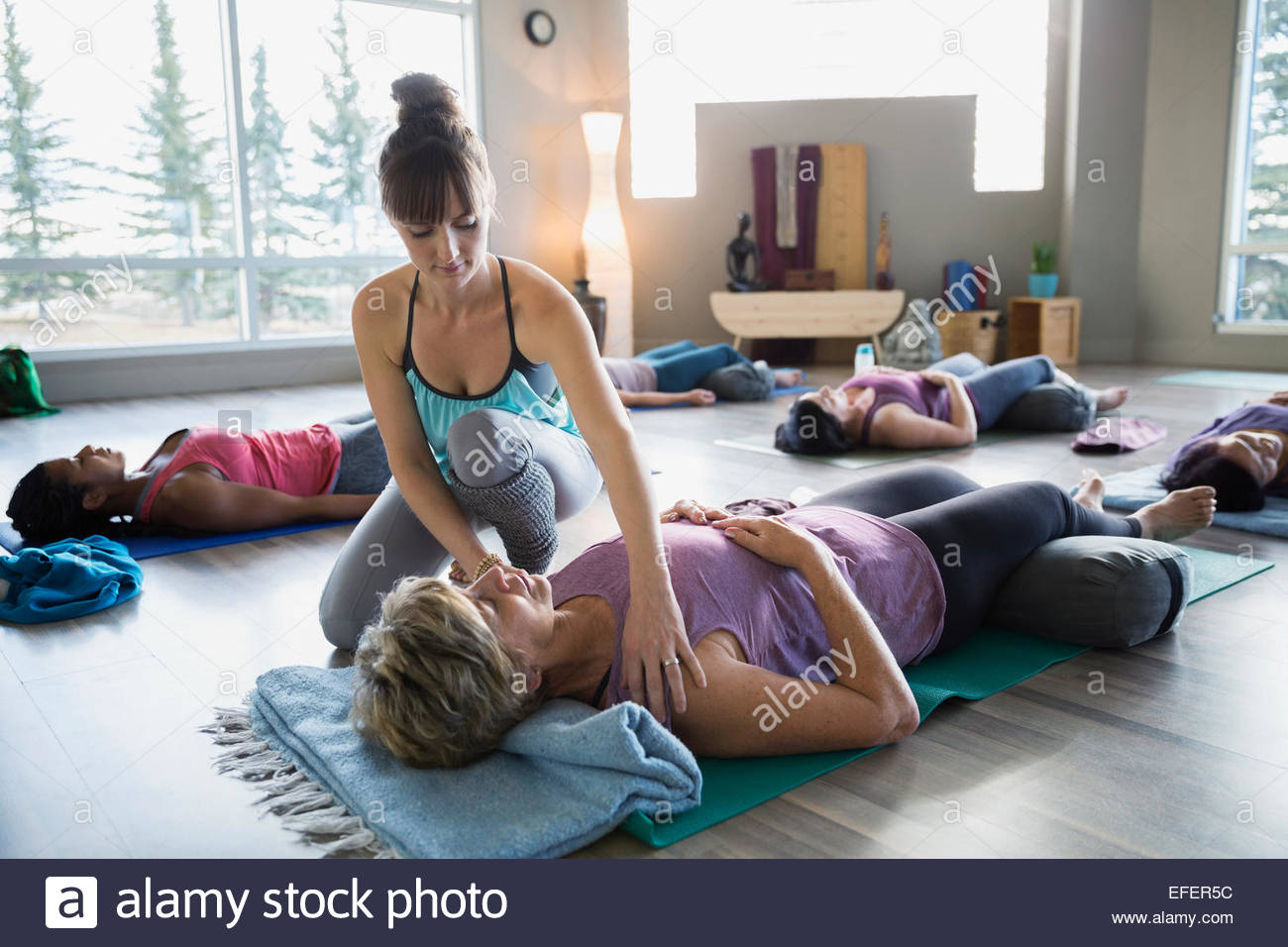 Lehrer Schüler Schultern Restoratives Yoga Klasse anpassen Stockfoto