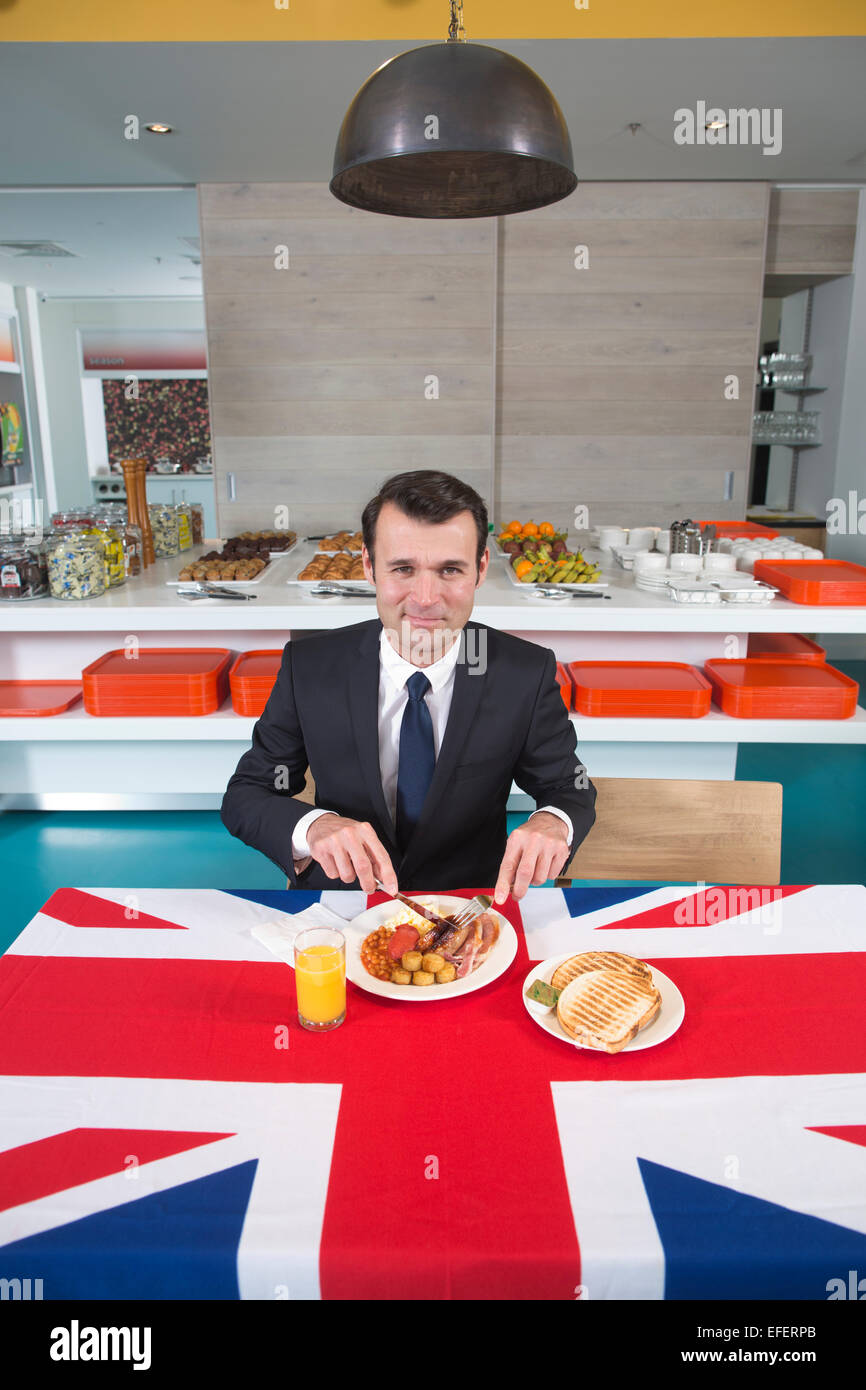 Kaufmann Essen ein komplettes englisches Frühstück serviert auf einer Tischdecke Anschluß-Markierungsfahne, Vereinigtes Königreich Stockfoto