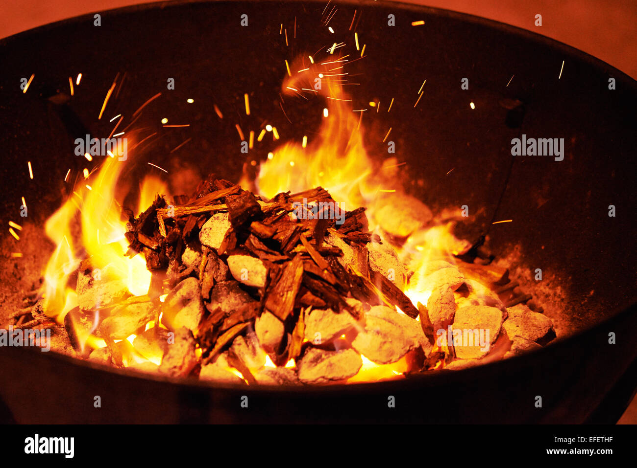 Feuer Grill mit Glut und Flammen und Holz in der Nacht Stockfoto