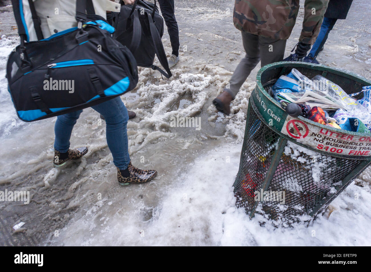 Fußgänger finden Ochsentour durch Pfützen, Matsch und Schnee an Straßenkreuzungen mit Schnee dam verstopfte Abflüsse im Stadtteil Chelsea in New York am Montag, 2. Februar. 2015. New Yorker auf dem Weg zur Arbeit konfrontiert geht es allen, Frost, Regen, Schnee und einfache Regen wie ein Sturm durch die Stadt. Temperaturen werden voraussichtlich fallen und mit mehr Niederschlag der bestehenden Matsch und stehendes Wasser schaltet auf gefährliche Eis.  (© Richard B. Levine) Stockfoto