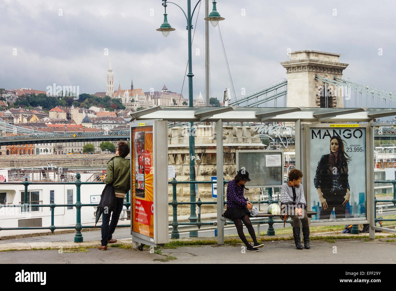 Straßenszene mit Menschen an einer Straßenbahnhaltestelle, Kettenbrücke und Burgviertel. Budapest, Ungarn Stockfoto