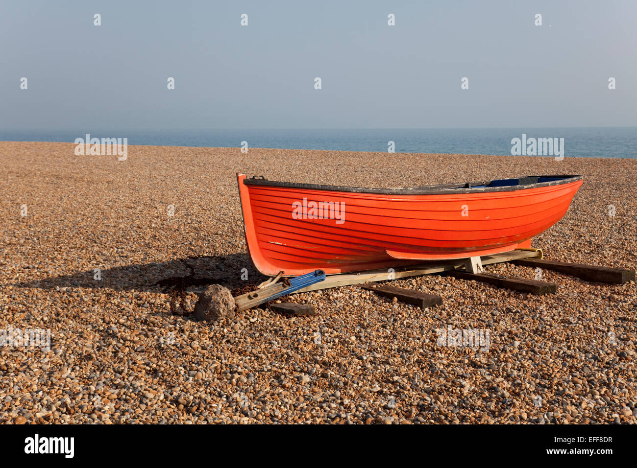 Kleines Orangenfischen oder Ruderboot am Kiesstrand, Brighton, England Stockfoto