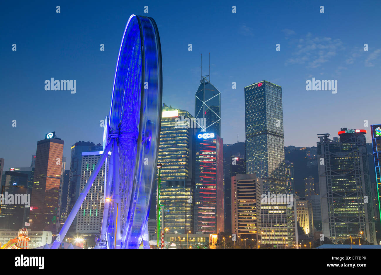 Riesenrad und Wolkenkratzer von Central bei Dämmerung, Hong Kong Island, Hongkong, China Stockfoto