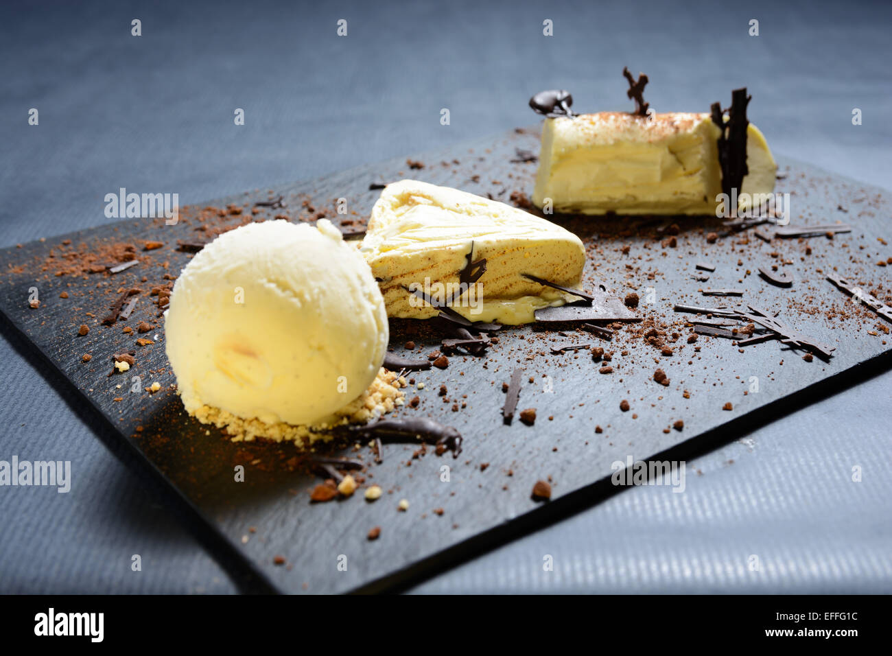 Weiße Schokolade und Vanille-Parfait mit Schokoladen Streusel auf einem schwarzen Schiefer Teller Stockfoto
