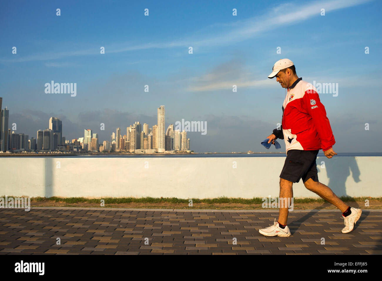 Mann läuft mit Panama Flagge T-shirt Cinta Costera Pazifik Küste Beltway Bahia de Panama linear Park Seawall Skyline Stockfoto