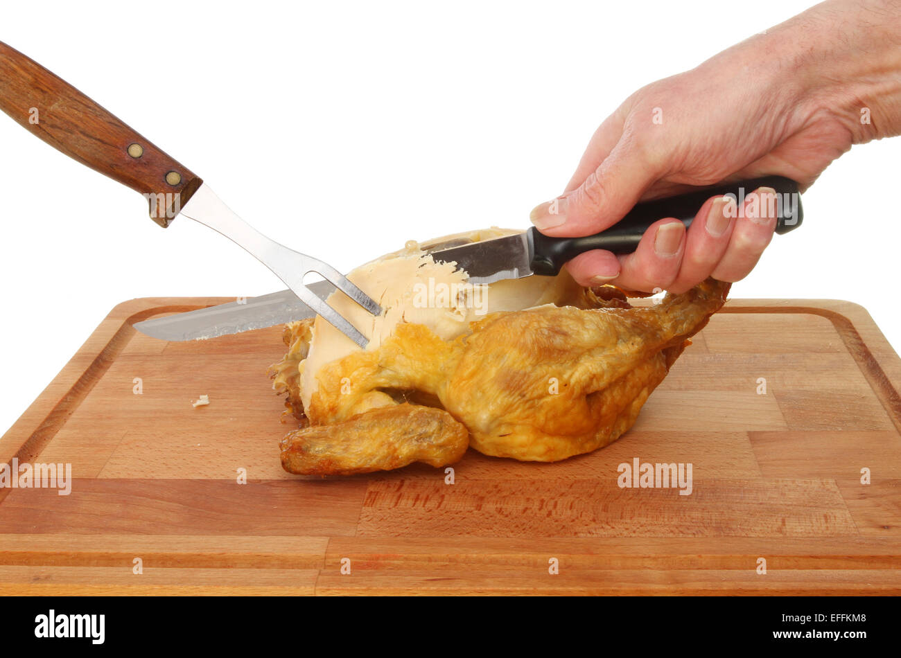 Hand mit Messer schnitzen ein gebratenes Huhn auf einem Holzbrett Stockfoto