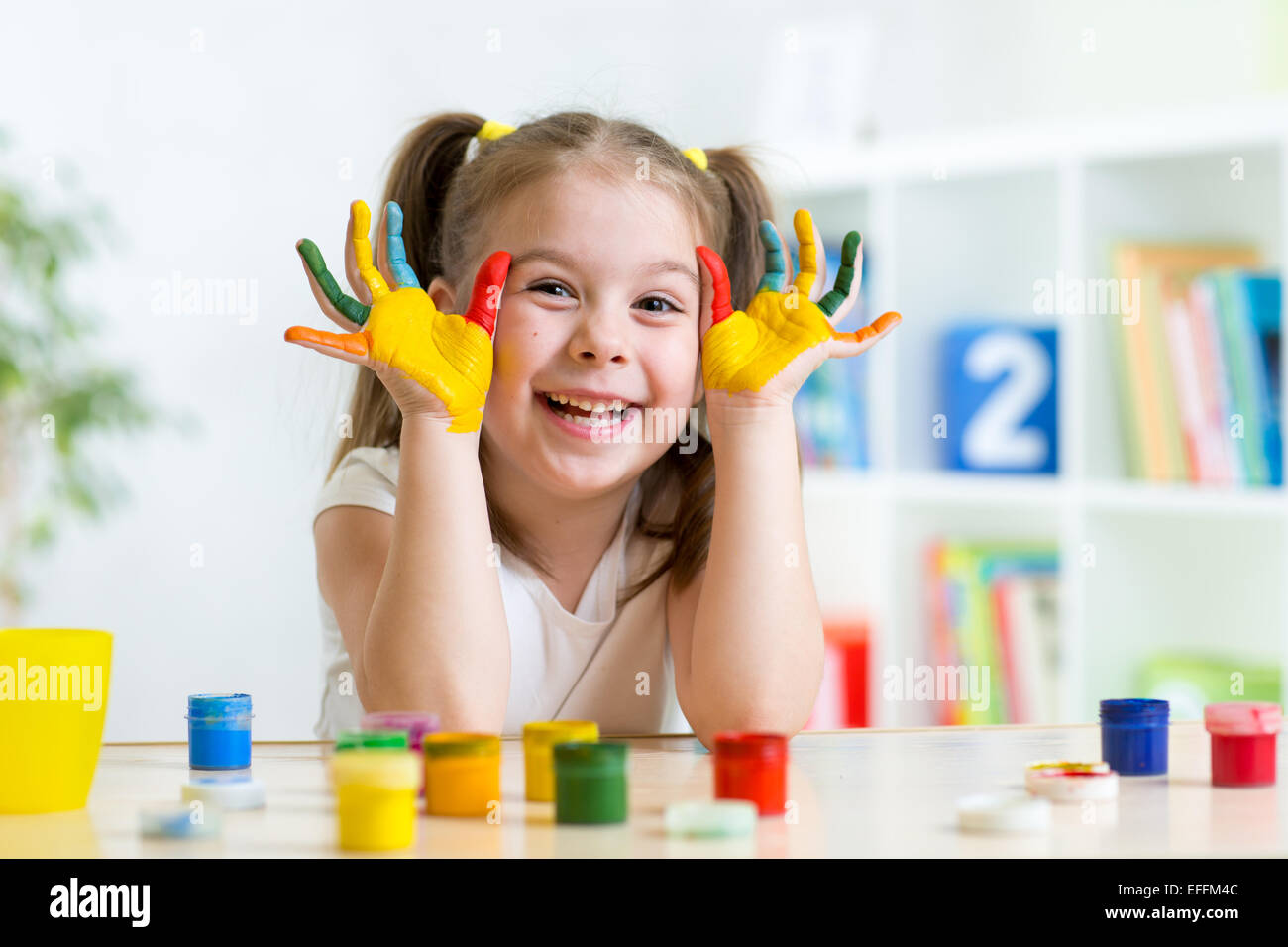 schönes Kind Mädchen mit Hände in Farbe Farben Stockfoto