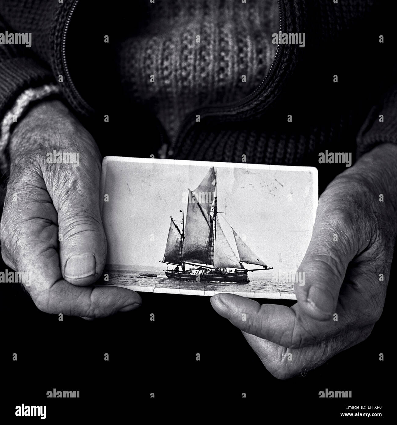 Fischer mit einem alten Foto von einem Segelschiff, in Schwarz und Weiß Stockfoto