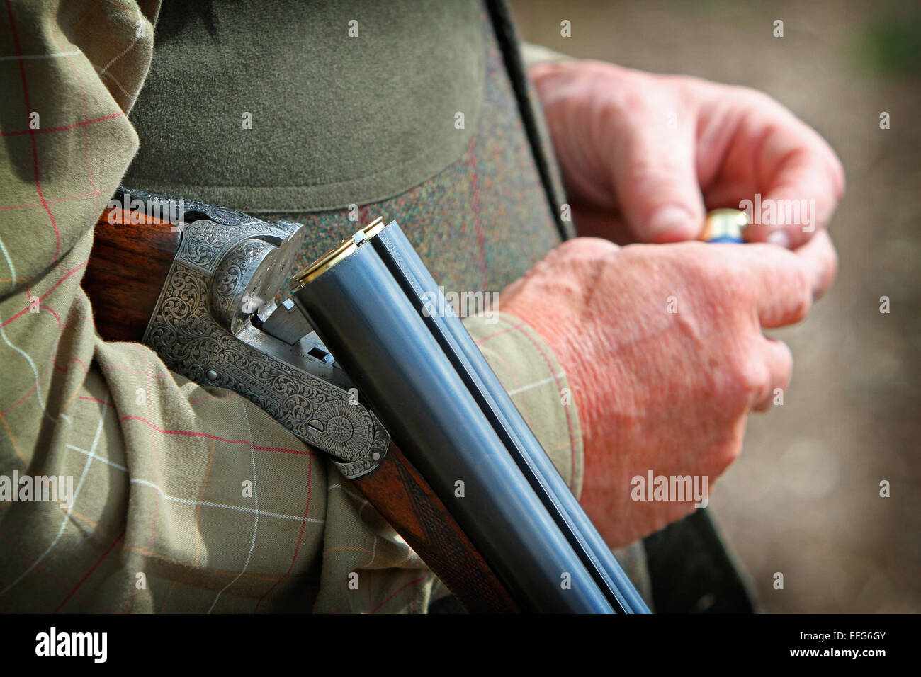 Mann Spiel Schießen mit Gewehr und Pistole der Entladerohrhalterung Patronen, Nahaufnahme 7/8 Stockfoto