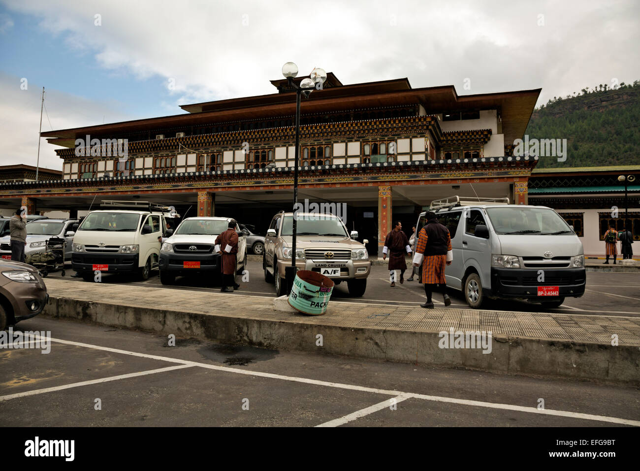 BHUTAN - Reiseleiter und Fahrer tragen die Ghos (Tracht), Abholung Kunden am internationalen Flughafen von Paro. Stockfoto