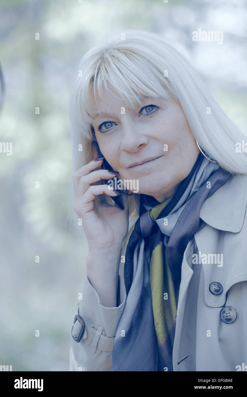 Ältere Frau glücklich telefonieren im freien Stockfoto