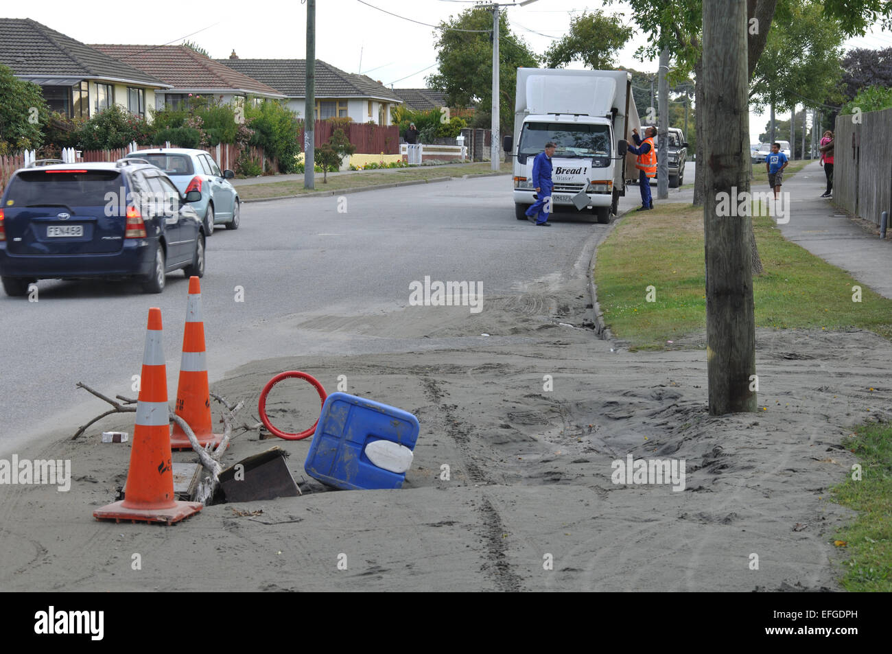 CHRISTCHURCH, NEW ZEALAND, 22. Februar 2011: Ein Auto fährt vorbei an eine Doline und Verflüssigung von dem Erdbeben der Stärke 6,4. Stockfoto