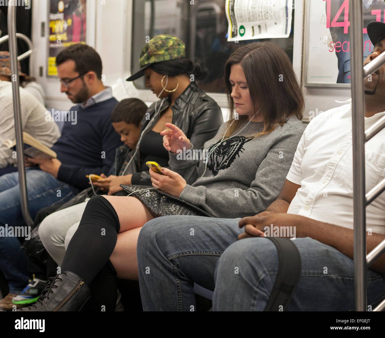 Die Menschen lesen, verwenden sie ihre Telefone und in der U-Bahn in New York City schlafen. Stockfoto