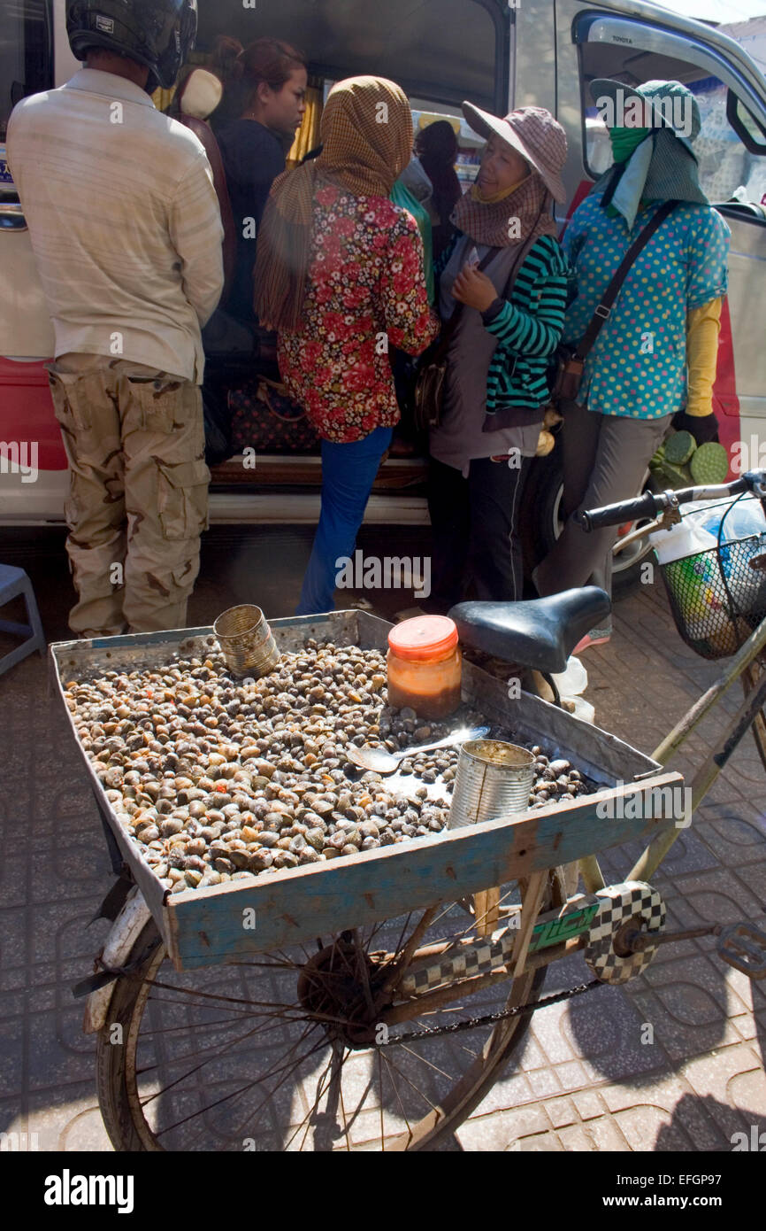 Schnecken sind erhältlich als Straße Nahrung ruht auf einem Fahrrad auf einer Stadtstraße in Kampong Cham, Kambodscha. Stockfoto