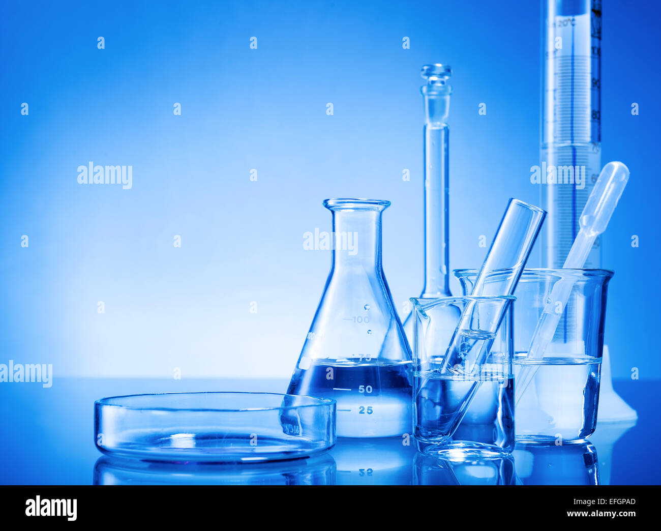 Laborgeräte, Glaskolben, Pipetten auf blauem Hintergrund Stockfoto