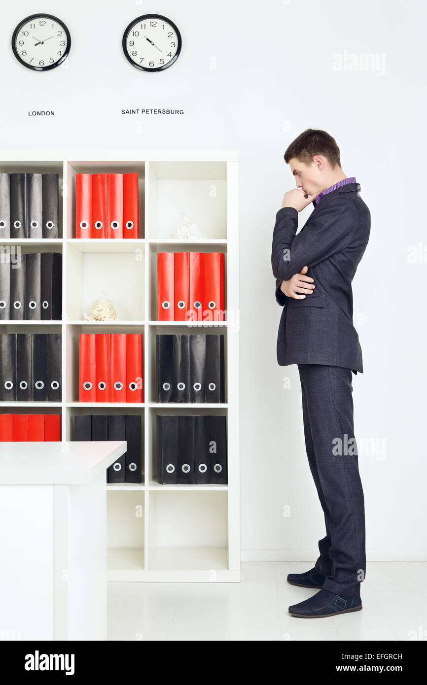 Geschäftsmann in seinem Büro in Gedanken versunken. Stockfoto