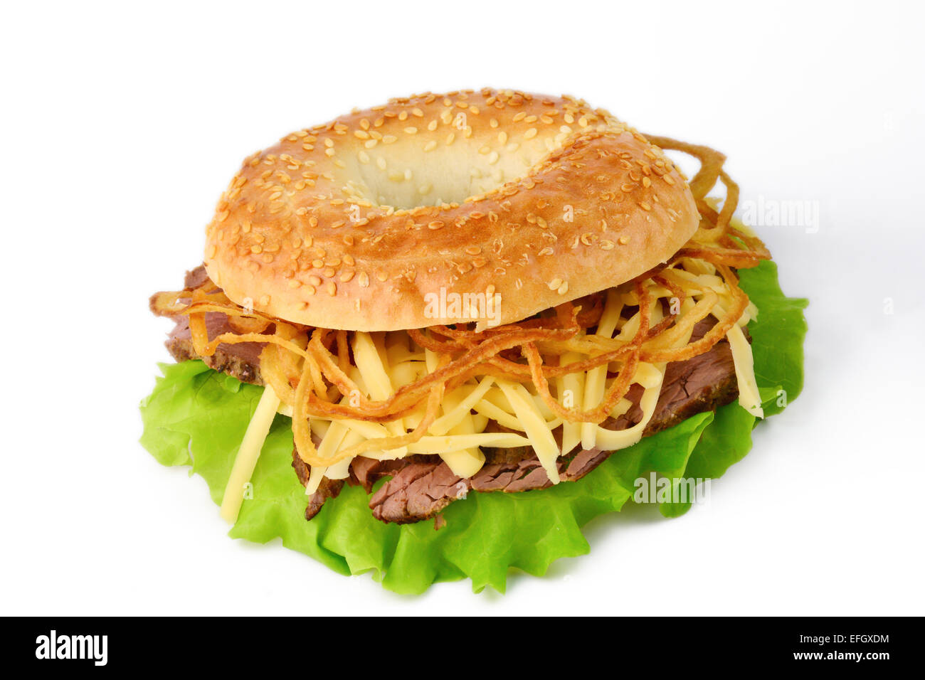 Studio isoliert: frische Sesam Bagel mit Salat, gebratenes Rindfleisch, geriebenen Cheddar-Käse und Zwiebel Ringe Stockfoto