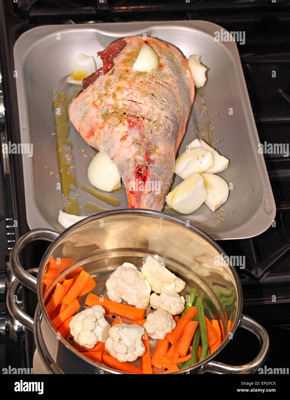 Essen kochen, einschließlich ein Joint-Lamm mit Zwiebeln in einen Bräter für Backofen und Gemüse in einem Dampfer bereit vorbereitet Stockfoto