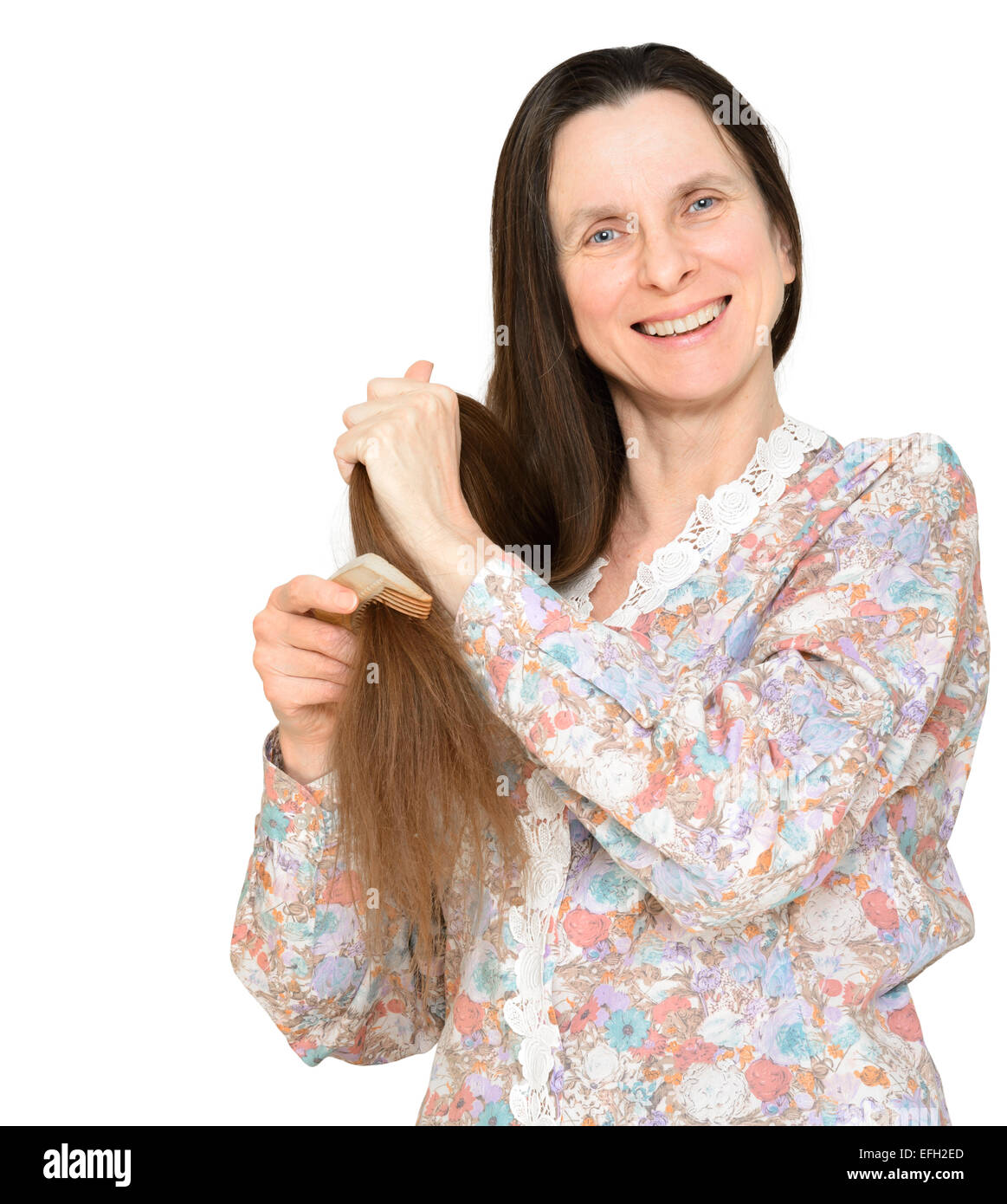 Erwachsene Frau lange braune Haare zu kämmen, mit einem hölzernen Kamm, isoliert auf weißem Hintergrund Stockfoto