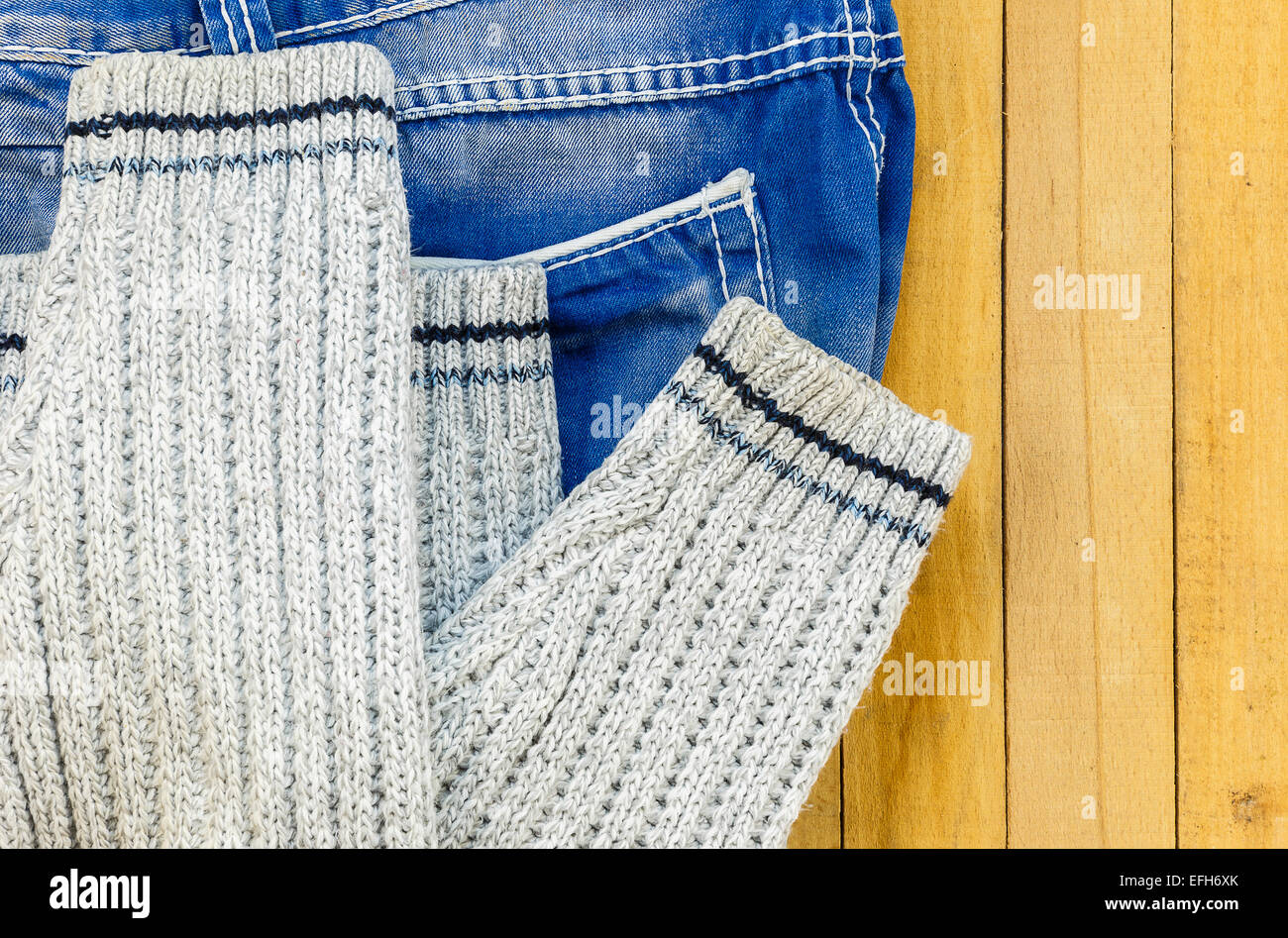 Jeans und Strickpullover auf den Brettern Stockfoto