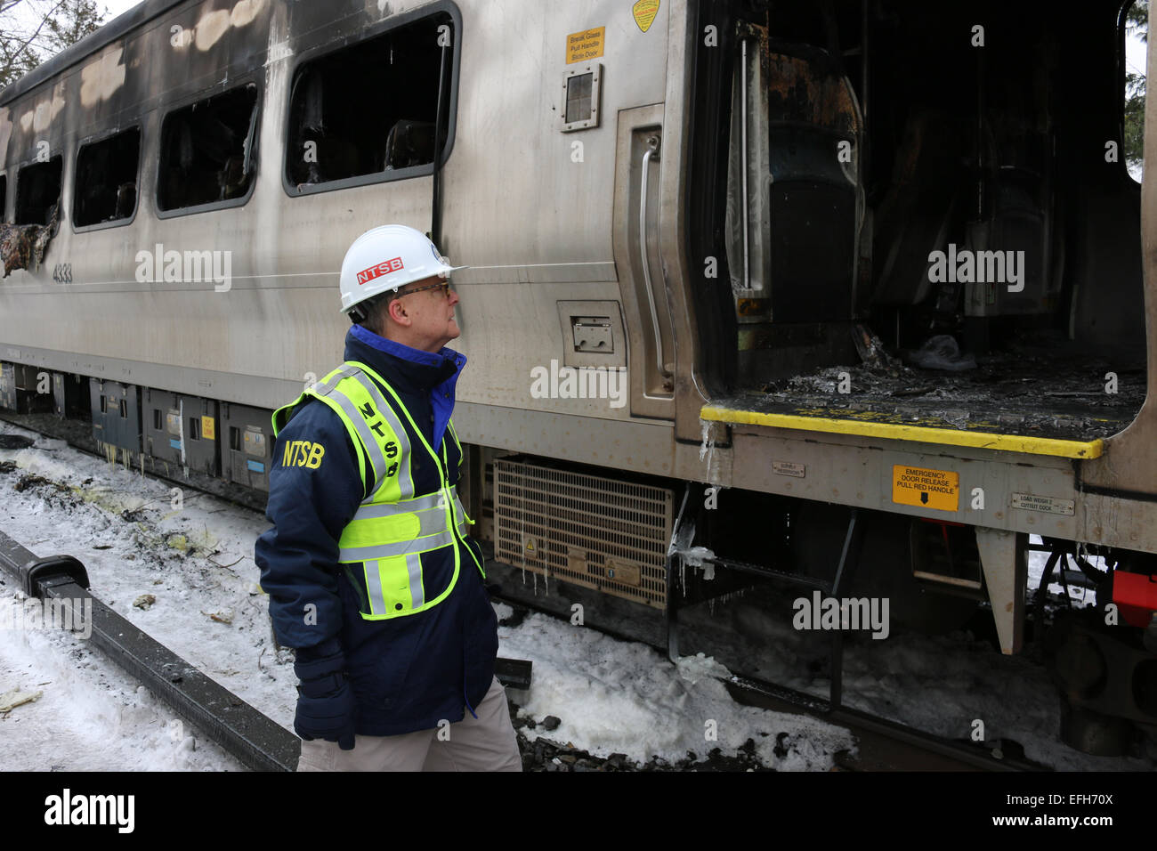 Eine NTSB Unfall-Ermittler Robert Sumwalt sieht den verkohlten Trümmern eine Metro North-Zug-Auto mit einem SUV kollidierte, sechs Menschen getötet und verletzt 12 verletzte 4. Februar 2015 in New York Westchester County. Stockfoto