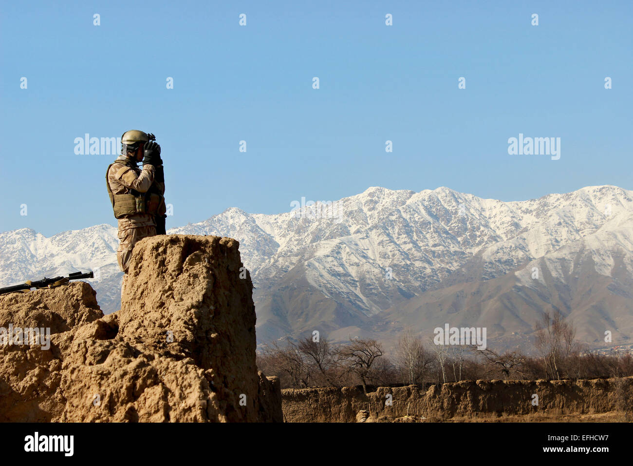 Eine tschechischer Spezialkräfte Kommando hält und Auge heraus für die Aufständischen Taliban während einer gemeinsamen Patrouille mit amerikanischen und afghanischen Soldaten in einem Dorf 27. Januar 2015 in Parwan Provinz, Afghanistan. Stockfoto