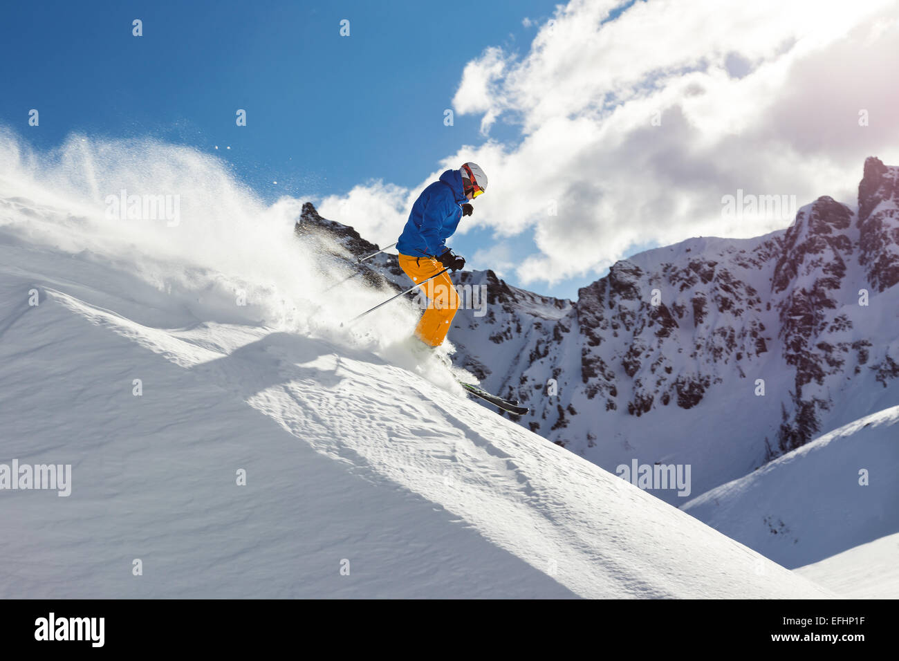 Männlichen Skifahrer auf downhill Freeride mit Sonne und Blick auf die Berge Stockfoto