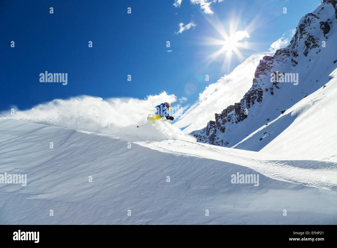 Männlichen Skifahrer auf downhill Freeride mit Sonne und Blick auf die Berge Stockfoto