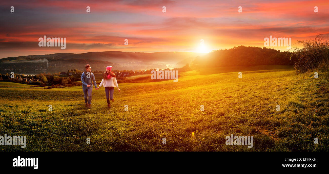 Liebendes Paar Hand in Hand laufen auf dem Feld. schöne Landschaft Stockfoto