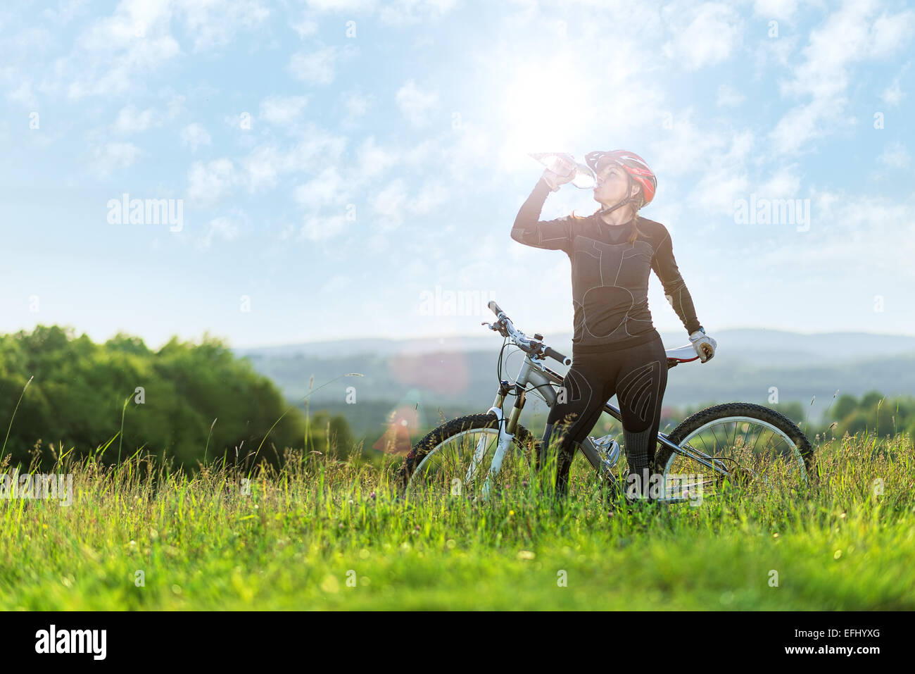 Sport Fahrrad Frau trinken auf einer Wiese, schöne Landschaft Stockfoto
