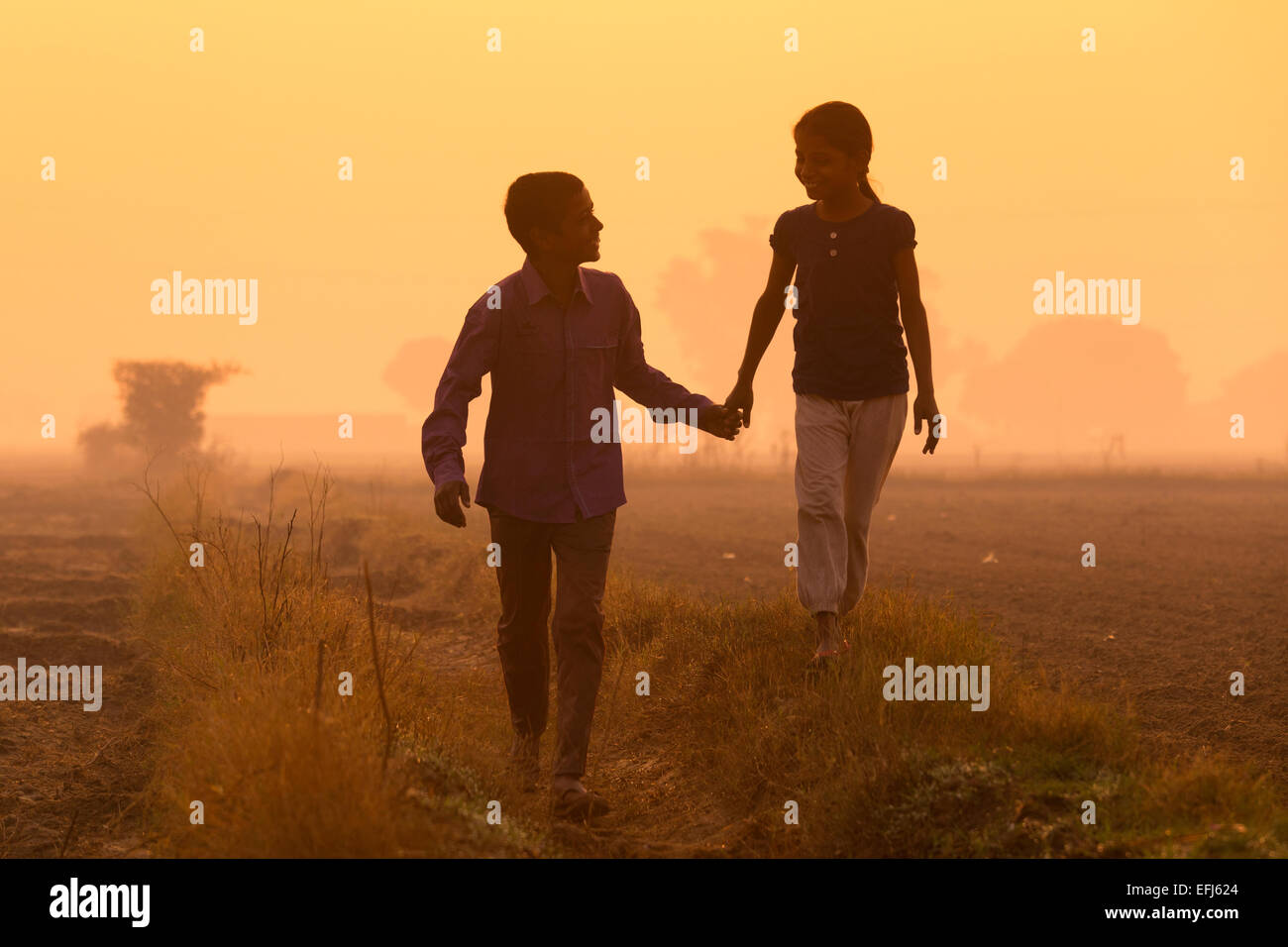 Indien, Uttar Pradesh, Agra, Bruder und Schwester, die Hand in Hand zu Fuß in Feld Stockfoto