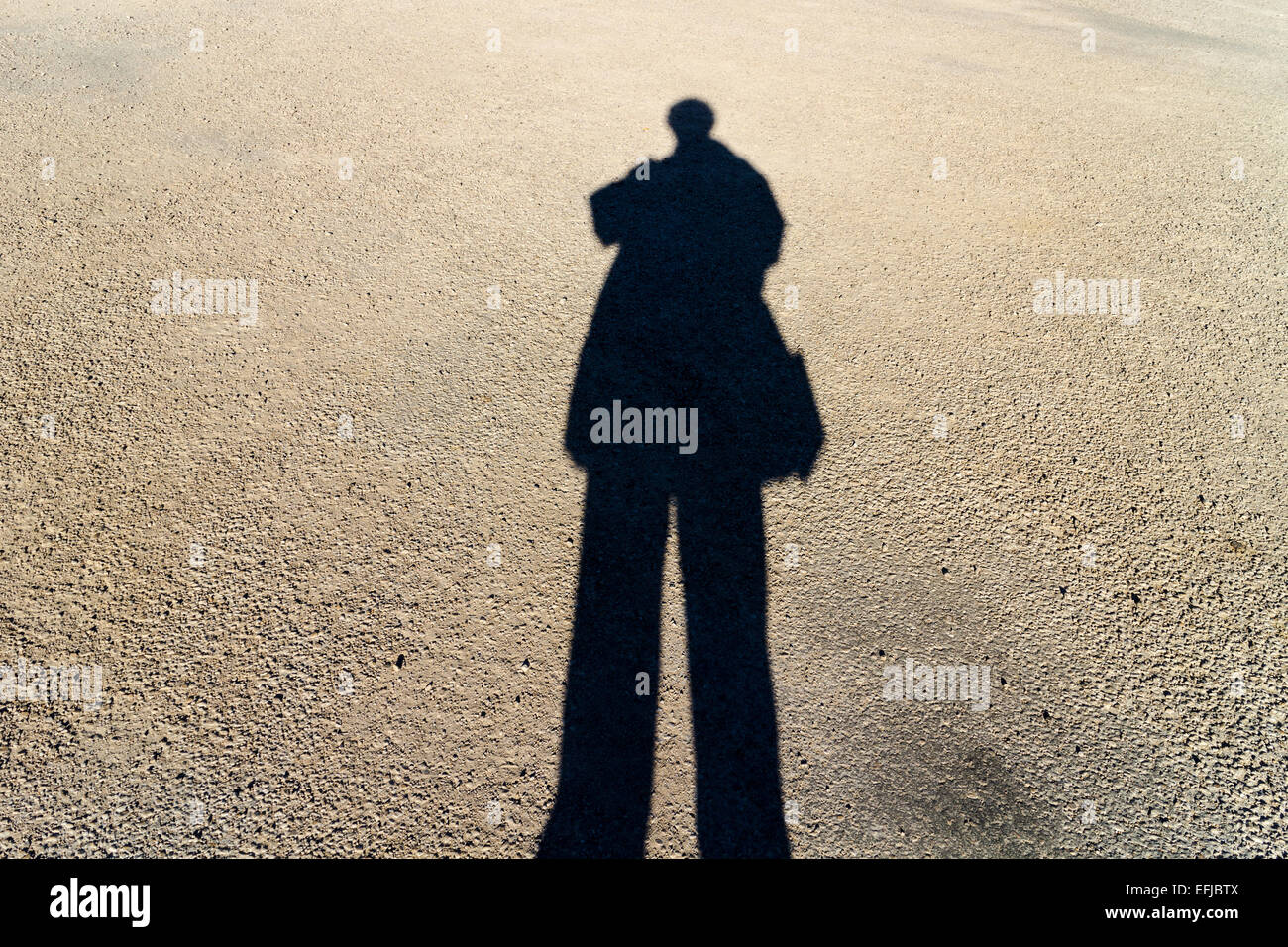 Längliche Schatten einer Person auf der Straße stehen Sonnentag Stockfoto