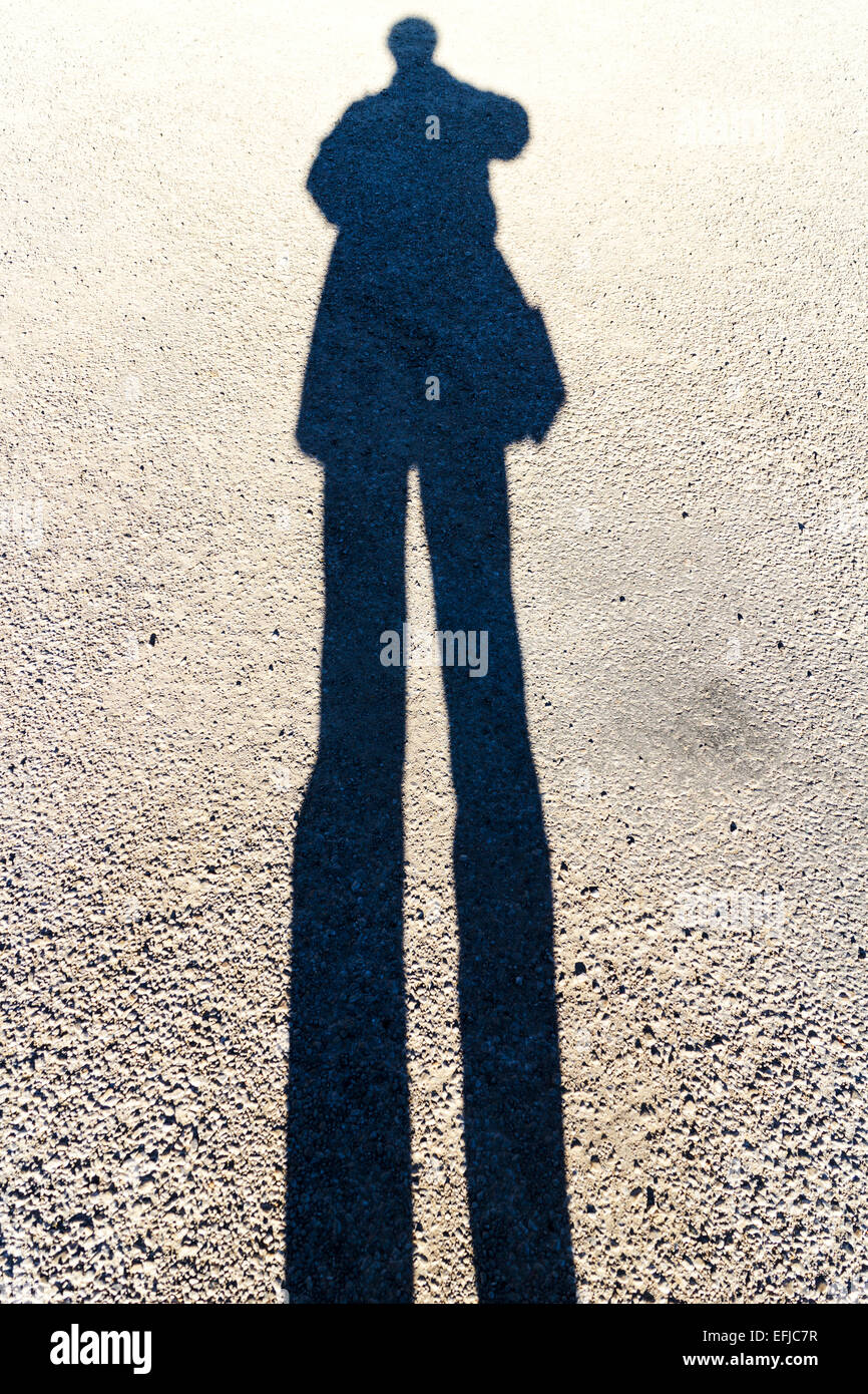 Längliche Schatten einer Person auf der Straße stehen Sonnentag Stockfoto