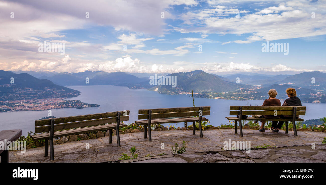 Damen auf einer Bank genießen Panorama des Lago Maggiore, Italien. Wolken nähert sich. Stockfoto