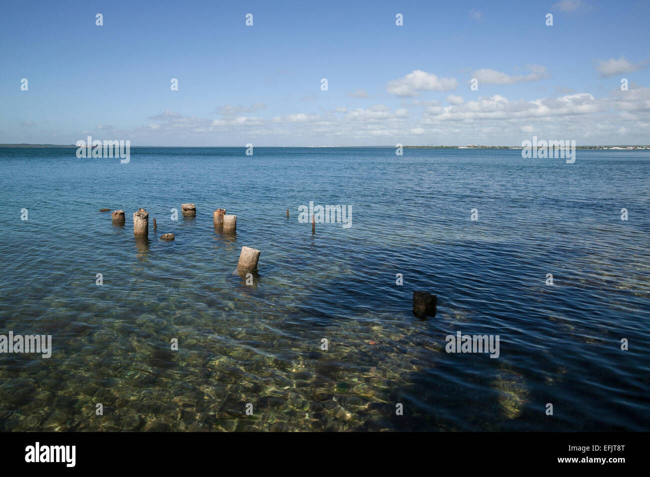 Alte Masten in das kristallklare blaue Wasser der Bucht von Cienfuegos, Punta Gorda, Cienfuegos, Kuba. Stockfoto