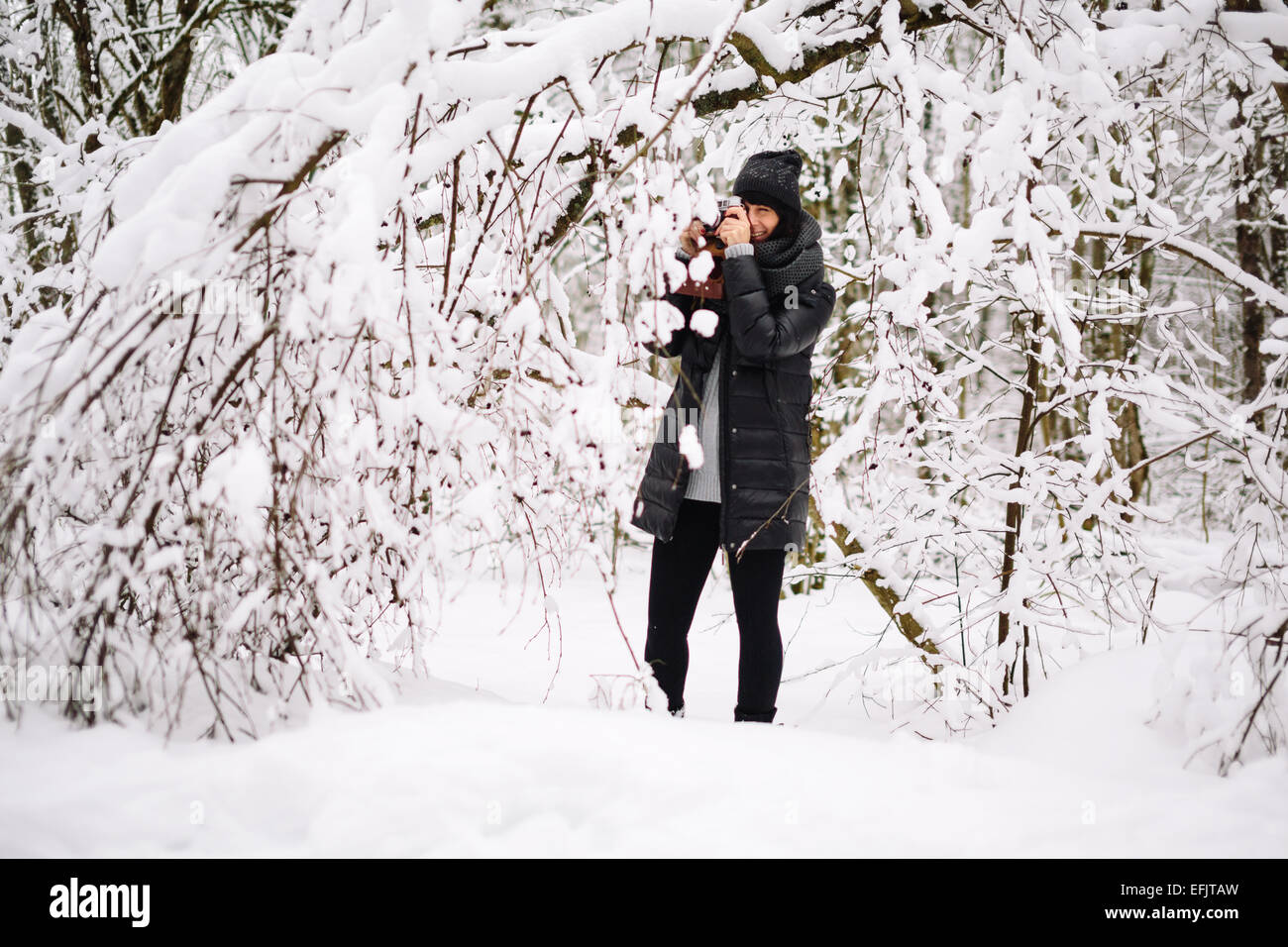 Mädchen im verschneiten Wald fotografiert Stockfoto