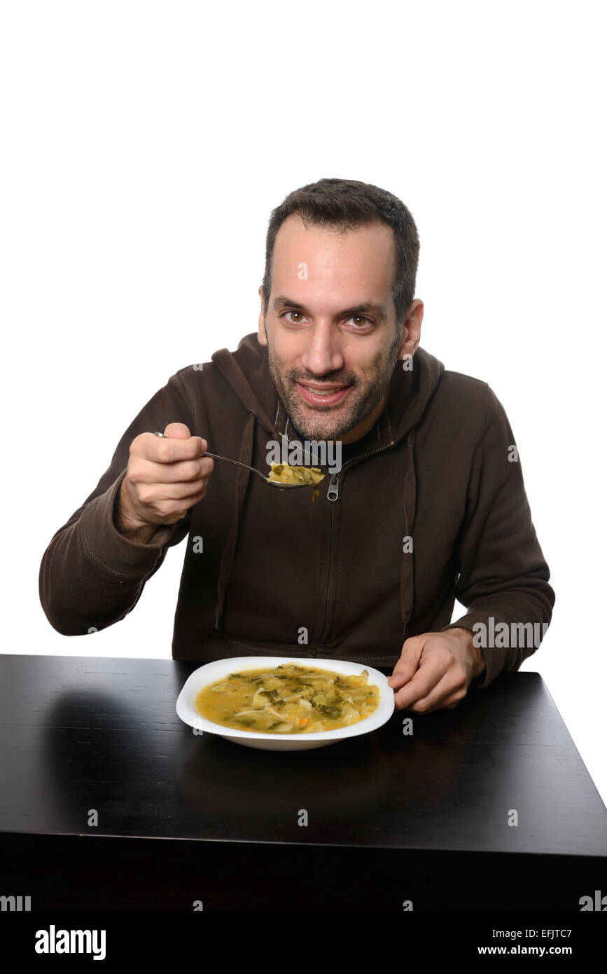 Junger Mann Essen Gemüsesuppe Stockfoto