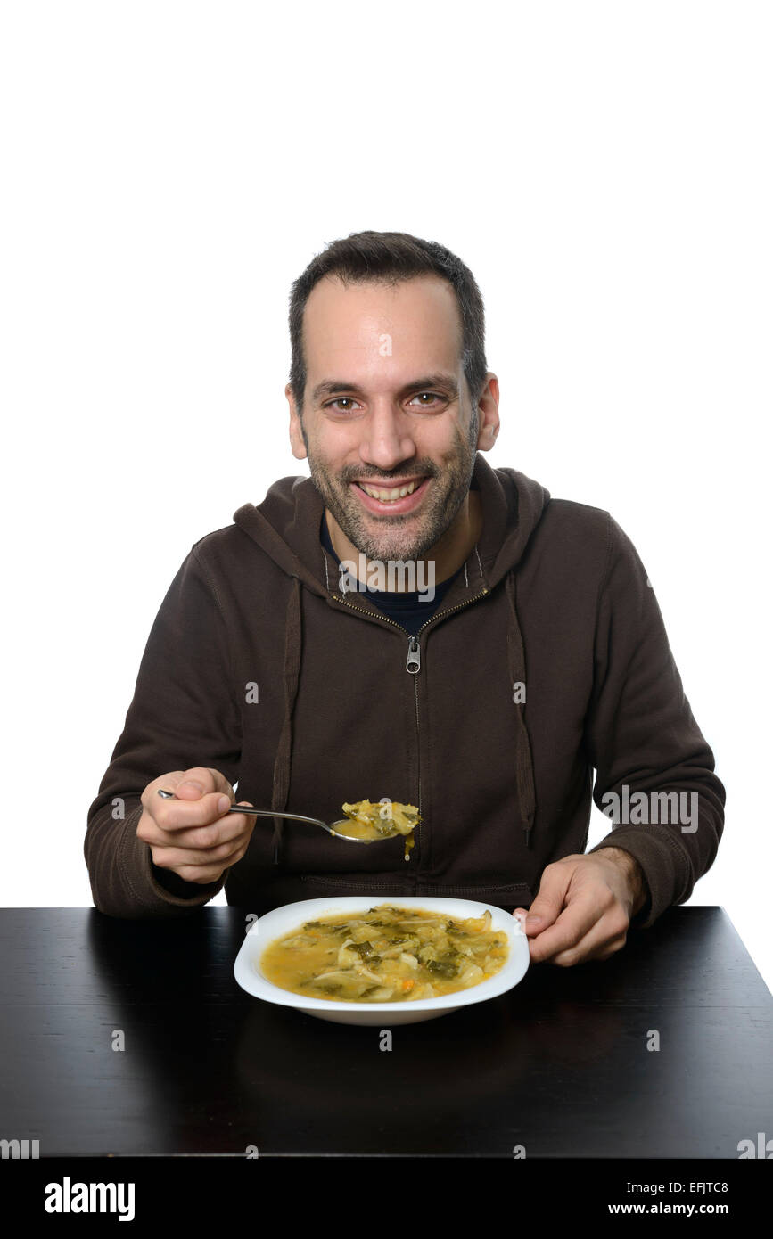 Junger Mann Essen Gemüsesuppe Stockfoto