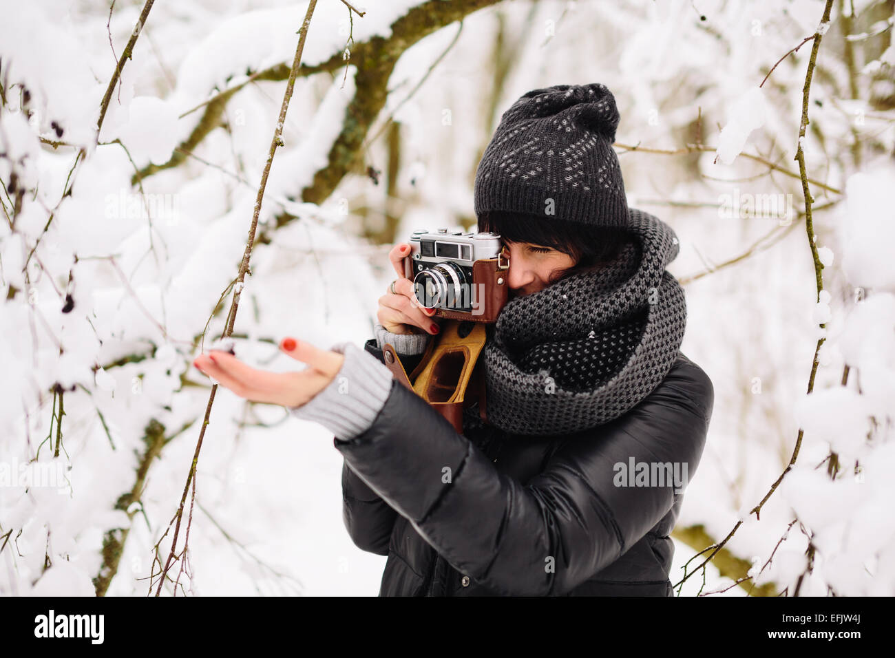 Mädchen im verschneiten Wald fotografiert Stockfoto