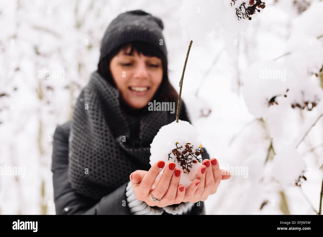 Mädchen und ein Zweig mit Schnee Stockfoto