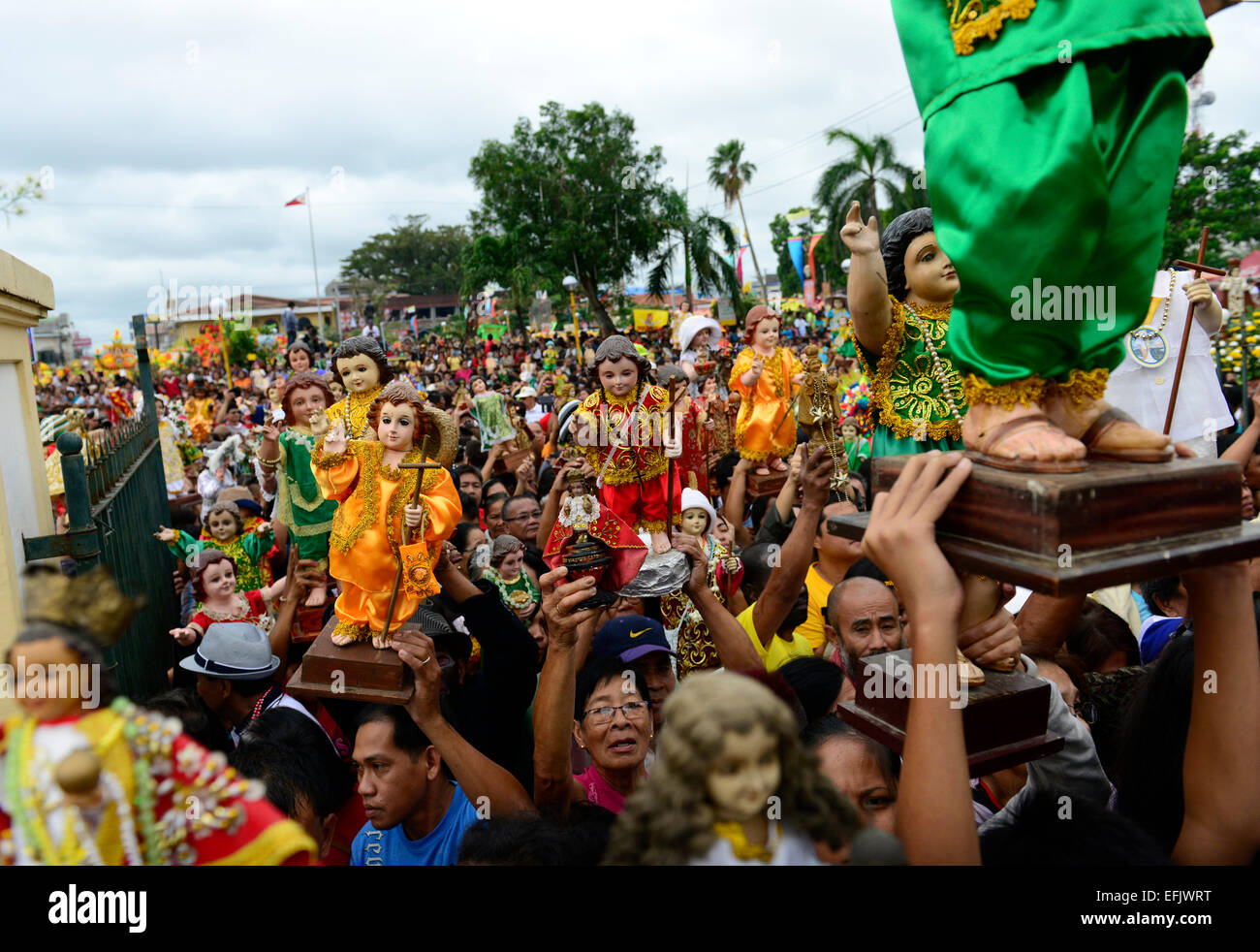 Ein Filipino krähte, kleine Statuen von Santo Niño (Jesuskind), in der Kathedrale von Kalibo nach Masse zu halten. Stockfoto