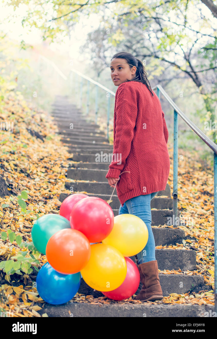 Schöne Mädchen mit ihren Luftballons beim Treppensteigen Stockfoto